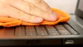 Service worker cleaning laptop keyboard buttons with microfibre cloth Royalty Free Stock Photo