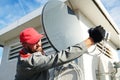 Service worker installing and fitting satellite antenna dish for cable TV Royalty Free Stock Photo