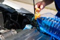 Service worker, pours in the tank washer fluid for washing car windows