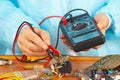 Serviceman checks electronic board with a multimeter Royalty Free Stock Photo