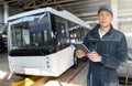 Serviceman with digital tablet on the background of the bus