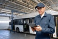 Serviceman with digital tablet on the background of the bus in the garage