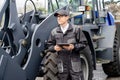 Serviceman with digital tablet on a background of the tractor