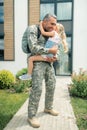Serviceman feeling emotional while hugging his crying happy daughter