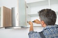 Serviceman Fixing Cabinet With Screwdriver In Kitchen