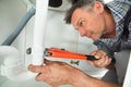 Serviceman Fixing Sink Pipe In Kitchen