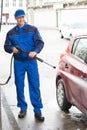 Serviceman With High Pressure Water Jet Washing Car Royalty Free Stock Photo