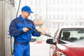 Serviceman With High Pressure Water Jet Washing Car Royalty Free Stock Photo