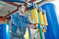 Serviceman operating industrial water purification or filtration equipment