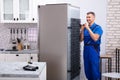 Serviceman In Overall Working On Fridge Royalty Free Stock Photo