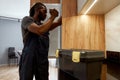 Serviceman in overalls checking fridge with flashlight Royalty Free Stock Photo