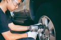 Serviceman removing bolt from a wheel using pneumatic gun, tire replacement Royalty Free Stock Photo