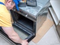 Serviceman removing electric oven door for easy access