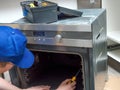 Serviceman repairing broken electric oven