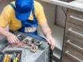 Serviceman replacing faulty part in the electric oven