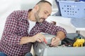 serviceman testing washing machine with multimeter