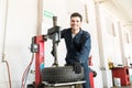 Serviceman In Uniform Using Tire Changer At Garage