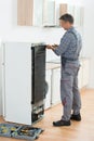 Serviceman Working On Fridge At Home Royalty Free Stock Photo