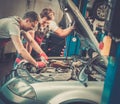 Servicemen in a car workshop Royalty Free Stock Photo