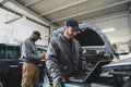 Servicemen making car diagnostics with laptop in a workshop Royalty Free Stock Photo