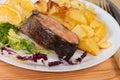 Serving of baked rainbow trout with potato, fragment close-up