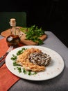 Sliced chicken breast with cream sauce and rice on a table with a serving board with spices, herbs and a bottle of olive oil Royalty Free Stock Photo