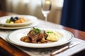 serving coq au vin on a plate, mashed potatoes aside