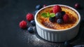 Creme brulee, finished with a scattering of fresh berries for a touch of freshness and visual appeal. It\'s presented