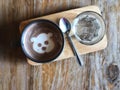 Serving cute dog face Latte art in Black cup and water glass on wooden tray and vintage wooden table Royalty Free Stock Photo