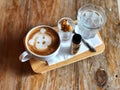Serving cute dog face Latte art and water glass on wooden tray and vintage wooden table