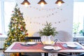 Serving a festive table with plates, forks, knives, napkins, glasses close-up in the modern interior of a loft house decorated for