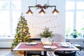 Serving a festive table with plates, forks, knives, napkins, glasses close-up in the modern interior of a loft house decorated for