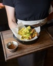 A Serving of french fries and deep fried snack with tomato sauce served by waiter in a plate.