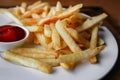 Serving of french fries on a plate, fragment. Natural light