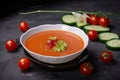 serving of gazpacho, garnished with cucumber and cherry tomatoes