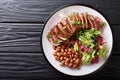 Serving grilled beef steak with fresh salad and beans close-up o Royalty Free Stock Photo