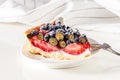 Serving homemade mix berry tart with fresh berries.