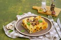 A serving of lasagna with pumpkin and mushrooms on ceramic plate on olive concrete background. Lasagna recipes. Pasta recipes