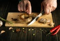 Serving a meat dish for lunch. The chef cuts homemade fried sausage on a wooden board. Cooking national meat dishes at home Royalty Free Stock Photo