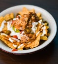 Serving of nachos with meat, cheese, white sauce and jalapenos Royalty Free Stock Photo