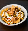 Serving of nachos with meat, cheese, white sauce and jalapenos Royalty Free Stock Photo