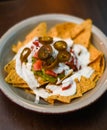 Serving of nachos with white sauce and jalapenos Royalty Free Stock Photo