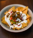 Serving of nachos with white sauce and jalapenos Royalty Free Stock Photo