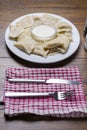 Serving of Polish dumplings on a wooden table and fork and knife on a red and white towel Royalty Free Stock Photo