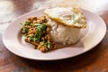 Serving of Prad Ka Pao, popular Thai steet food made up of fried minced pork with basil and fried egg with rice Royalty Free Stock Photo