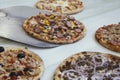 Serving a set of different mini pizzas on wooden table. Small pizzas