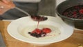 Serving sweet semolina porridge with berry syrup