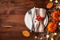 Serving for Thanksgiving dinner with plate, napkin, cutlery and pumpkins top view. Autumn table setting Royalty Free Stock Photo