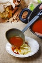 Serving tomato soup. Pouring soup into a plate Royalty Free Stock Photo