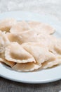 Serving of traditional Polish pierogy dish on a white plate. Dumplings filled with meat, cheese and mushrooms. Popular Eastern